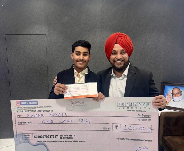 Handing a student his scholarship cheque for One Lakh Rupees