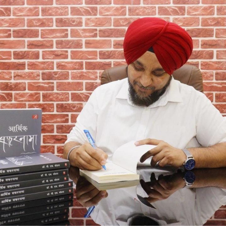 Dr. P. S. Vohra signing copies of आर्थिक सफ़रनामा.